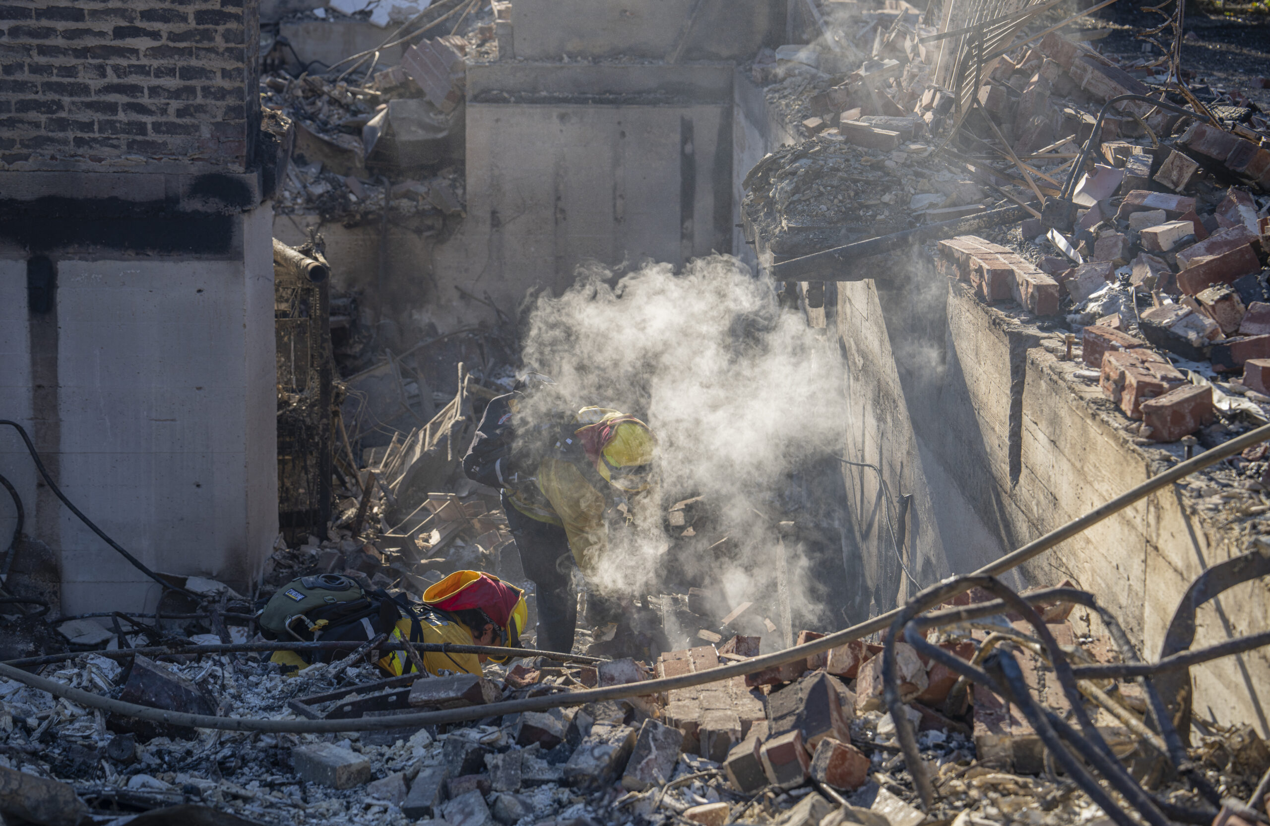 Fire Emergency Services sifts through the ashes of a home in Altadena on January 13, 2025